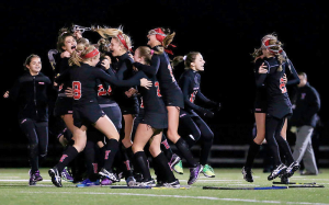 Photo courtesy of Lisa Manuzza The field hockey team runs onto the field to celebrate their victory and title of State Champs. 